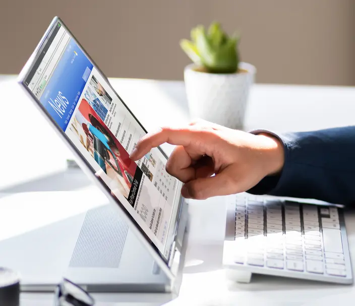 Person looking at news on laptop