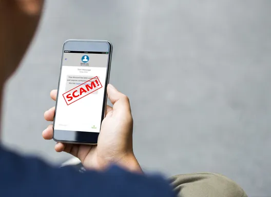 Man holding cell phone with a scam message
